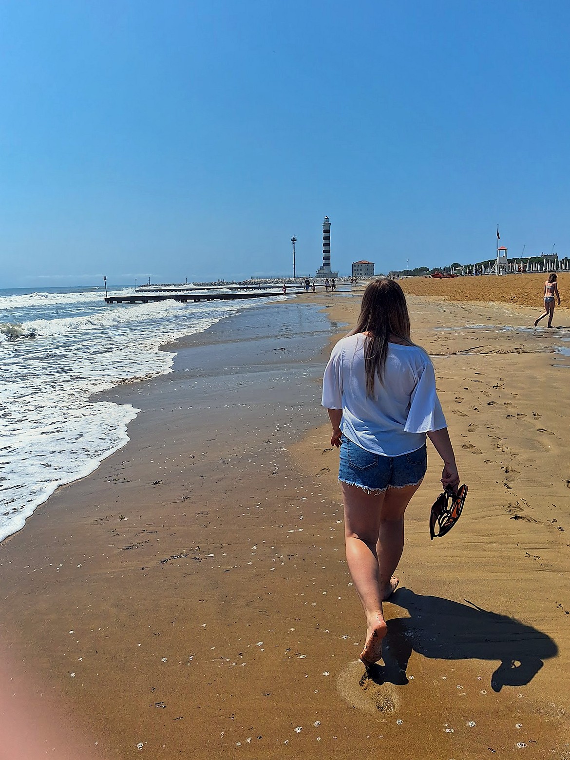 Walking along Lido di Jesolo beach toward the lighthouse