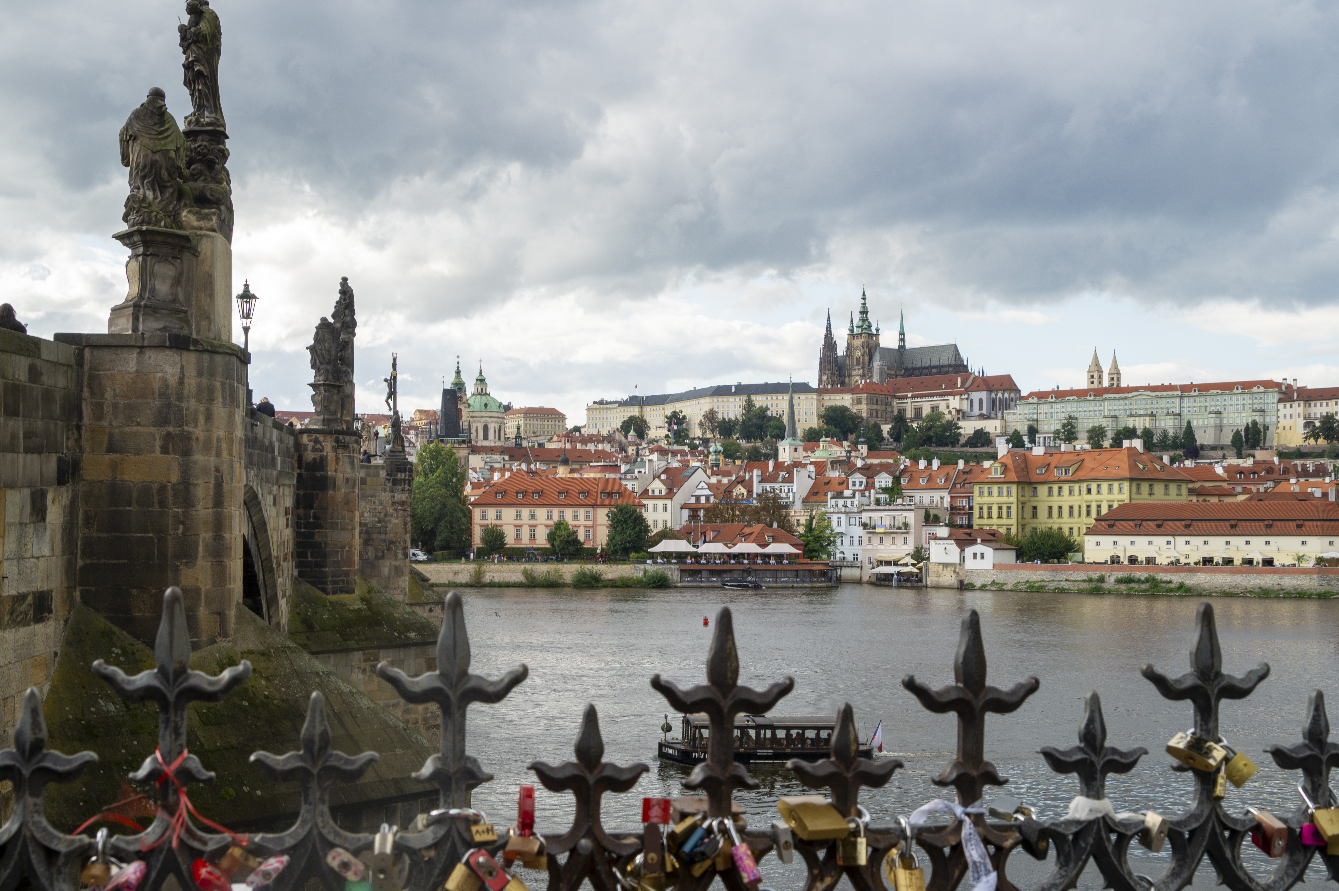 View from Charles Bridge with love locks attached to the railing in the foreground, the Vltava and Prague Castle with St Vitus Cathedral on the far hill