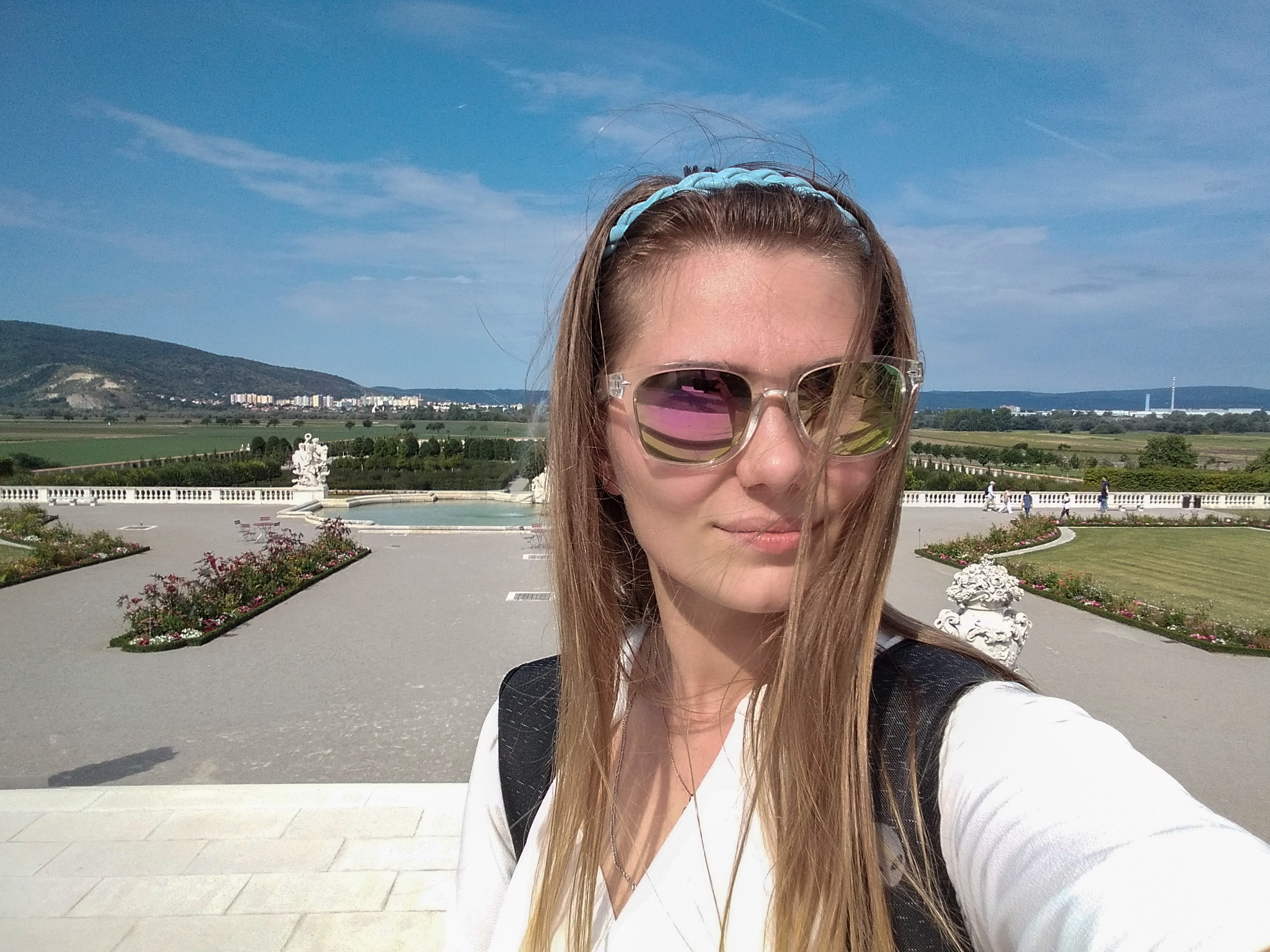 On the terrace of Schloss Hof above the green baroque parterres with a circular fountain, bright sunny August day